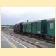 Parn lokomotiva 433.002 posunuje se soupravou vlaku ve stanici Krom.